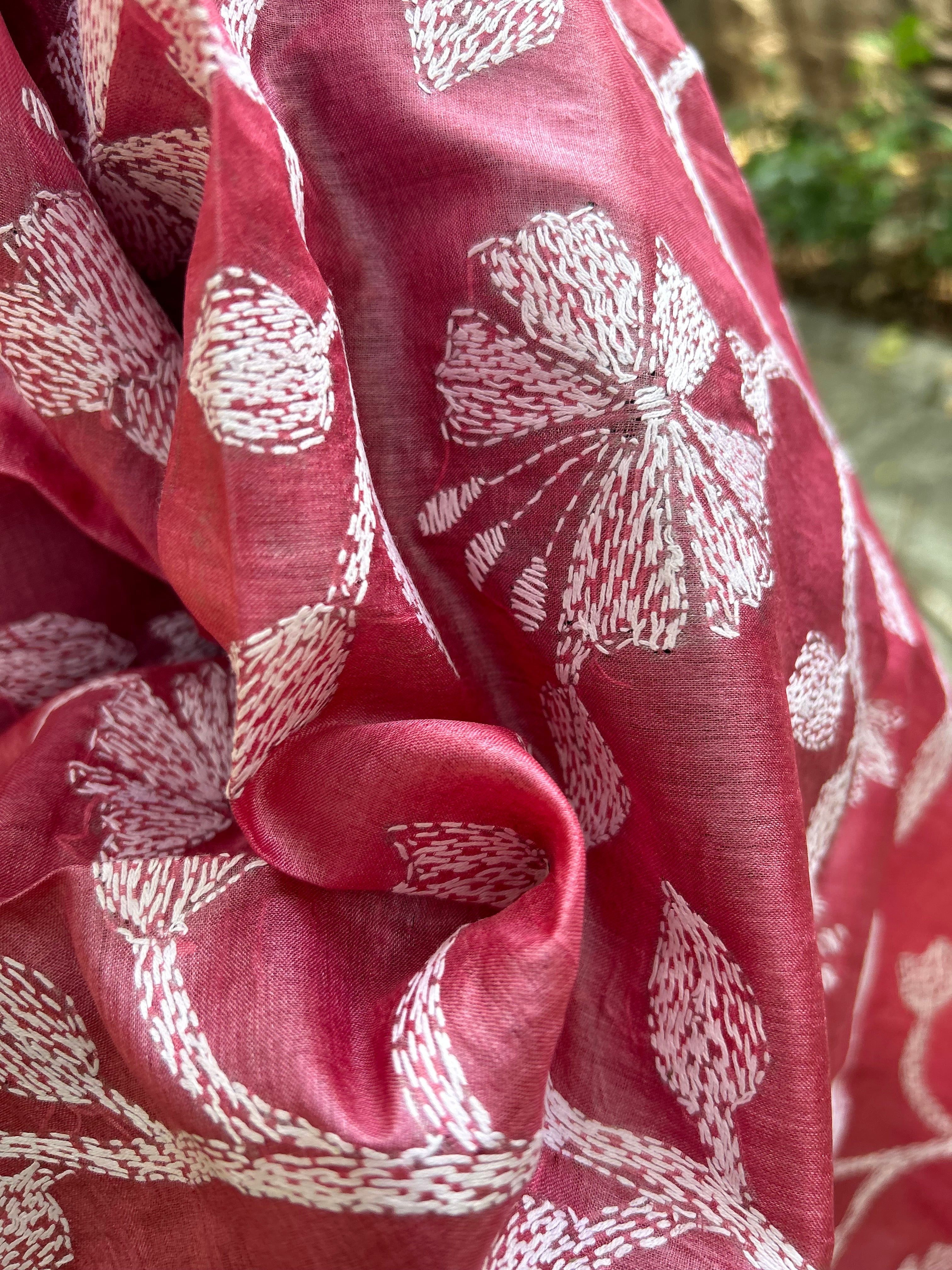 Elegant pure silk dupatta in peach Orange color, featuring intricate Kantha embroidery with vibrant floral and paisley motifs. The dupatta boasts a luxurious sheen and a rich texture, perfect for adding a touch of sophistication to any outfit. The hand-embroidered details highlight the traditional craftsmanship and artistry, making it a statement accessory for festive occasions or special events.