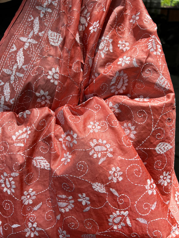 Elegant pure silk dupatta in peach Orange color, featuring intricate Kantha embroidery with vibrant floral and paisley motifs. The dupatta boasts a luxurious sheen and a rich texture, perfect for adding a touch of sophistication to any outfit. The hand-embroidered details highlight the traditional craftsmanship and artistry, making it a statement accessory for festive occasions or special events.