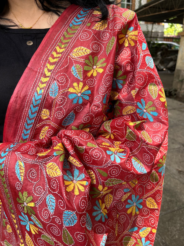 Elegant pure silk dupatta in peach Orange color, featuring intricate Kantha embroidery with vibrant floral and paisley motifs. The dupatta boasts a luxurious sheen and a rich texture, perfect for adding a touch of sophistication to any outfit. The hand-embroidered details highlight the traditional craftsmanship and artistry, making it a statement accessory for festive occasions or special events.