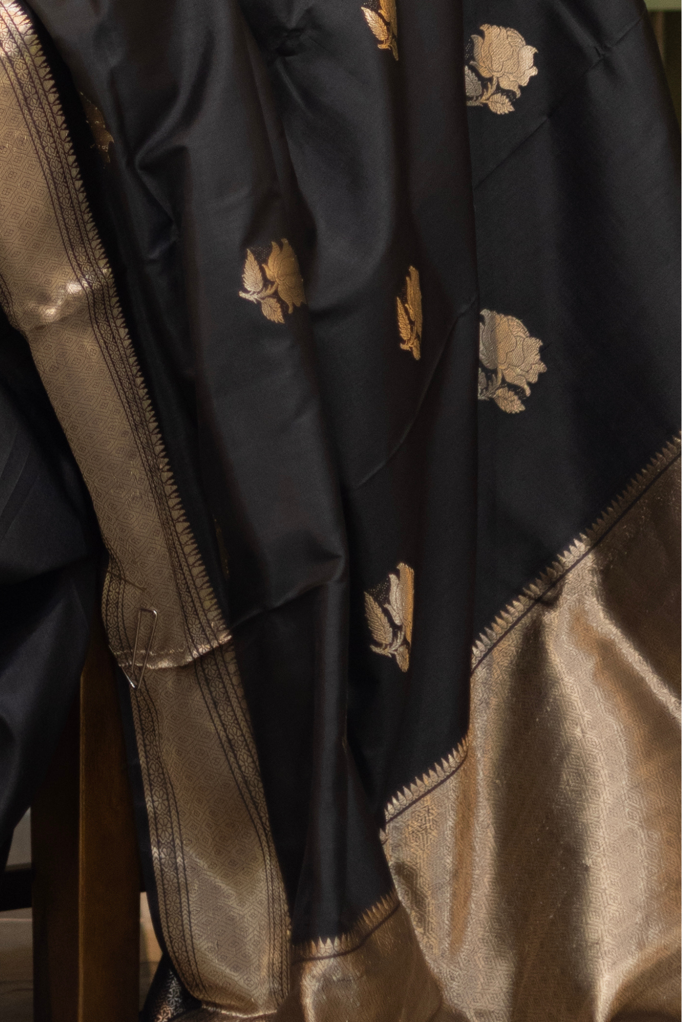 Woman in a black saree with gold patterns sitting indoor. Woman wearing a traditional baluchari saree in a room with a desk and lamp. Woman in a carrot red and silver resham work saree standing indoors with a desk and lamp in the background.

Baluchari – Pure Silk Baluchari Saree

1. “Pure silk Baluchari saree with temple motif weave and Silver resham detailing for a regal look.”

2. “Silk Mark pure silk saree featuring intricate gold resham work motifs and rich texture. 